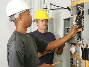 Two Electricians Fixing a panel